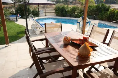 a wooden table with two pumpkins on it next to a pool at Bay Villas in Pissouri