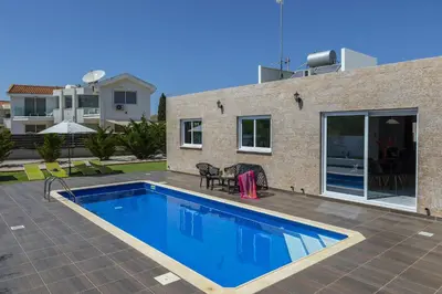 a swimming pool in front of a house at Protaras Villa Hollywood in Protaras