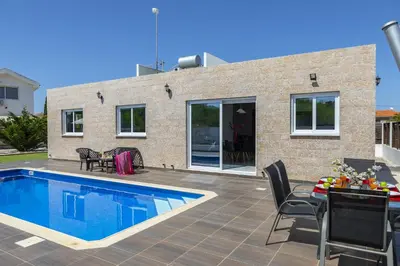 a patio with a swimming pool and a house at Protaras Villa Hollywood in Protaras