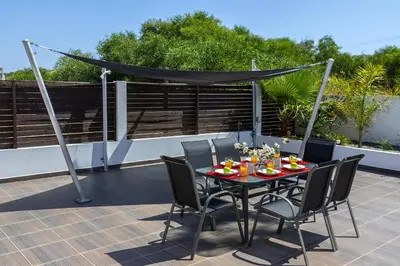 a table with chairs and a canopy on a patio at Protaras Villa Hollywood in Protaras