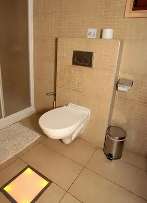 a bathroom with a toilet in a tiled wall at Ithaki Phinikoudes Apartment 307 in Larnaka