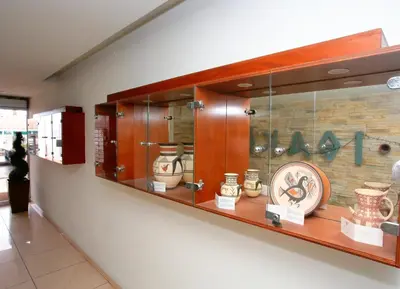 a display case with vases and a clock on a wall at Ithaki Phinikoudes Apartment 307 in Larnaka