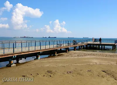 a pier on the beach with boats in the water at Ithaki Phinikoudes Apartment 307 in Larnaka