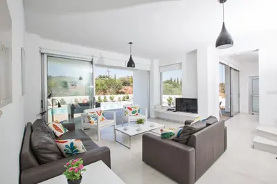 a living room with two couches and a fireplace at Greco Villas in Protaras