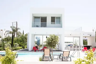 a white house with a pool and chairs at Greco Villas in Protaras