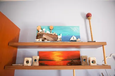 a wooden shelf with a painting of the ocean at Aquarian Beachfront Apartment in Larnaka
