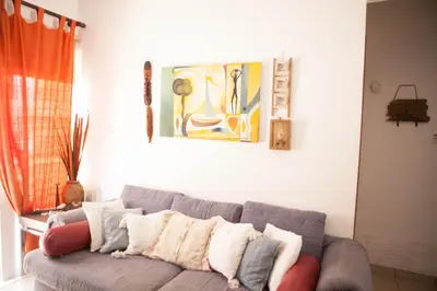 a living room with a gray couch with pillows at Aquarian Beachfront Apartment in Larnaka