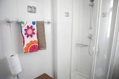 a bathroom with a shower and a painting on the wall at Aquarian Beachfront Apartment in Larnaka