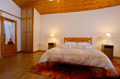 a bedroom with a bed with two night stands and two lamps at The Old Olive Mill House by TrulyCyprus in Doros