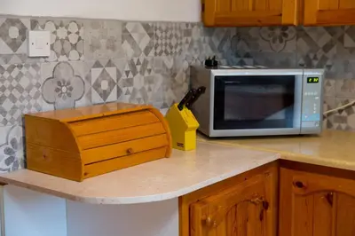 a kitchen counter with a microwave and a knife block at The Old Olive Mill House by TrulyCyprus in Doros