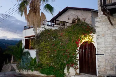 a building with flowers on the side of it at The Old Olive Mill House by TrulyCyprus in Doros