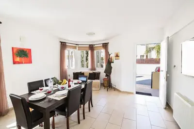 a dining room and living room with a table and chairs at Nancy Villas in Protaras