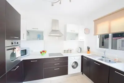 a kitchen with a sink and a washing machine at Nancy Villas in Protaras