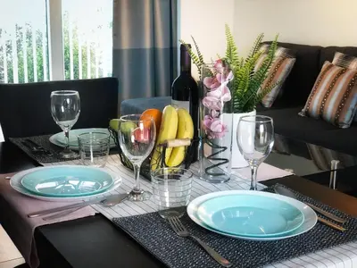 a table with plates and glasses and a bottle of wine at Silver Sea Holiday Apartments in Ayia Napa