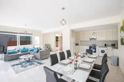 a dining room and living room with a table and chairs at Shaye Front Line Villa in Protaras