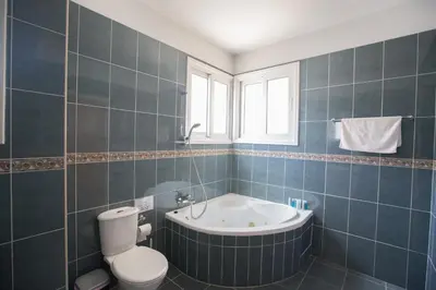 a bathroom with a tub and a toilet and a sink at Shaye Front Line Villa in Protaras