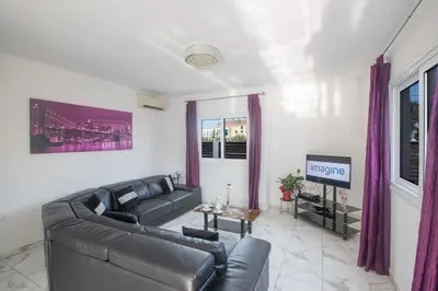 a living room with a couch and a tv at Broadway Villas in Protaras