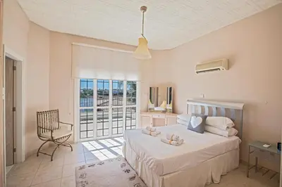 a bedroom with a bed and a chair and a window at Papas Family Villa in Paralimni