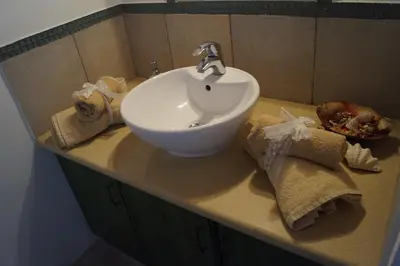 a bathroom sink with a towel and a basket ofngth at Makrinari Tis Pano Geitonias in Salamiou