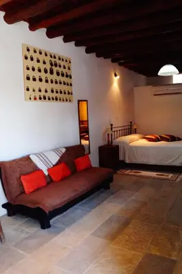a living room with a couch and a bed at Makrinari Tis Pano Geitonias in Salamiou