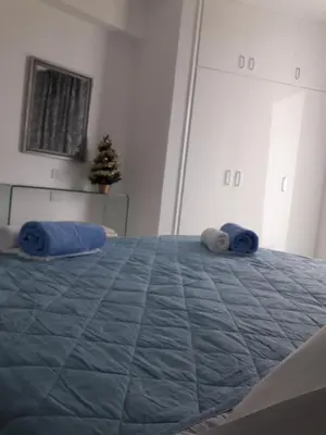 a bedroom with a bed with blue pillows on it at P L Sunorama Beach Garden 302 in Larnaka