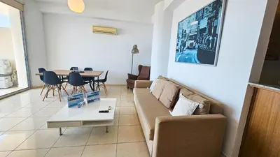 a living room with a couch and a table at Paradise Palms Seaview Apartment in Larnaka