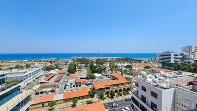 an aerial view of a city with buildings and the ocean at Paradise Palms Seaview Apartment in Larnaka