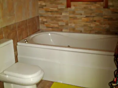 a bathroom with a white tub and a toilet at Agros Timber Log House in Agros