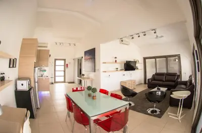a living room with a table and chairs in a room at Olivier Residence in Nicosia