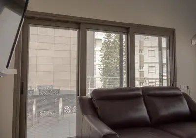 a leather couch sitting in front of a large window at Olivier Residence in Nicosia