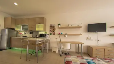 a kitchen with a table and chairs and a refrigerator at Olivier Residence in Nicosia
