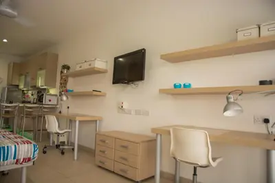 a room with desks and chairs and a tv on the wall at Olivier Residence in Nicosia