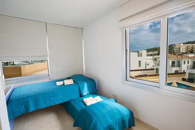 a blue couch in a room with a window at Pallinio Fig Tree Bay Apartments in Protaras