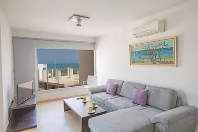 a living room with a couch and a table at Pallinio Fig Tree Bay Apartments in Protaras