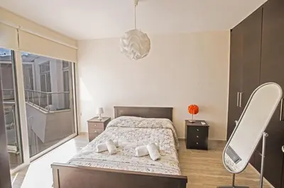 a bedroom with a bed and a mirror at Pallinio Fig Tree Bay Apartments in Protaras