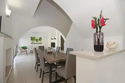 a dining room and living room with a table and chairs at Villa Regina in Ayia Napa