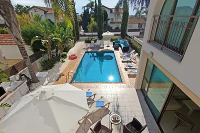 an overhead view of a swimming pool with chairs and umbrellas at Villa Regina in Ayia Napa