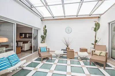 a conservatory with a glass ceiling and chairs and a living room at Leana Front Line Villa in Protaras