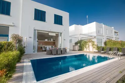 a swimming pool in front of a white house at Leana Front Line Villa in Protaras