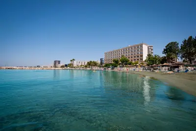 a body of water with a beach and buildings at Crowne Plaza Limassol by IHG in Limassol
