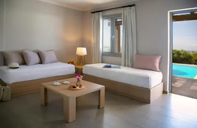 a hotel room with two beds and a coffee table at Louis St. Elias Resort & Waterpark in Protaras