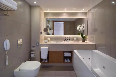 a bathroom with a sink and a toilet and a mirror at Royal Apollonia by Louis Hotels in Limassol