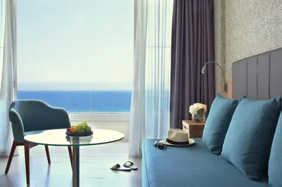 a living room with a blue couch and a table at Royal Apollonia by Louis Hotels in Limassol