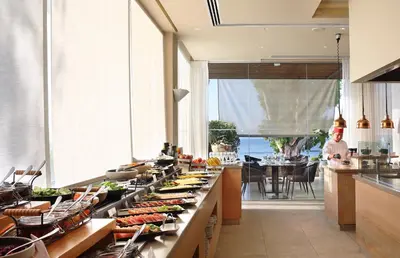 a buffet line with food on it in a kitchen at Royal Apollonia by Louis Hotels in Limassol