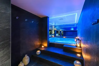 a bathroom with a tub with blue lighting and vases at Ajax Hotel in Limassol