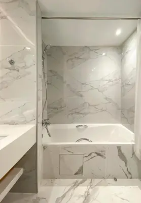 a white bathroom with a tub and a sink at Ajax Hotel in Limassol