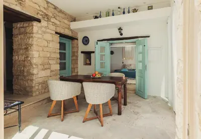 a dining room with a wooden table and chairs at Archondia House - Holiday Apartments With Pool in Kalavasos
