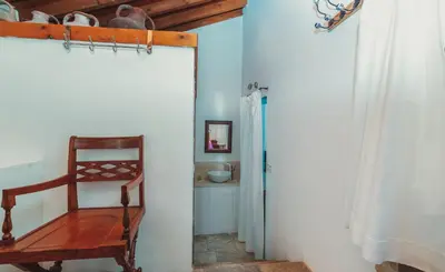 a room with a wooden chair and a door at Archondia House - Holiday Apartments With Pool in Kalavasos