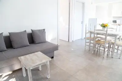 a living room with a couch and a table and chairs at Tikay Holiday Apts in Ayia Napa
