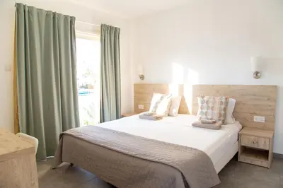 a bedroom with a large bed and a window at Tikay Holiday Apts in Ayia Napa
